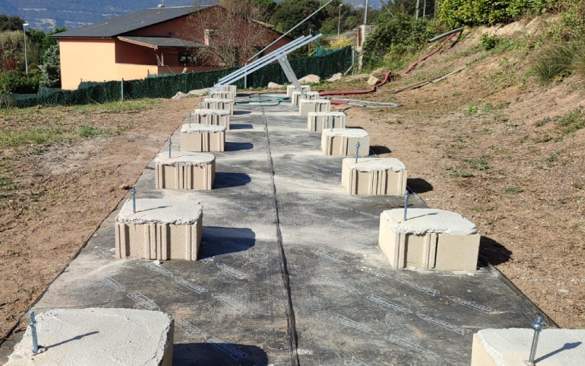 Estructura d'alumini fixada sobre blocs de formigó encastats al terra